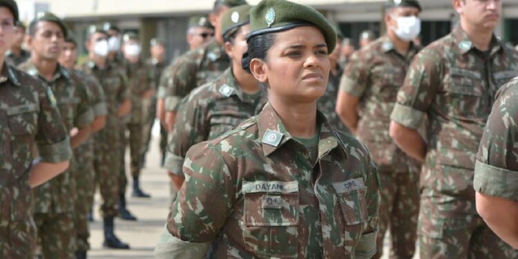 Soldado Dayane, mulher negra do Exército, perfilada com boina verde entre militares em cerimônia