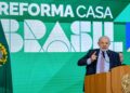 Presidente Lula discursa em púlpito com brasão da República, gesticulando, com painel verde do Reforma Casa Brasil ao fundo