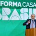 Presidente Lula discursa em púlpito com brasão da República, gesticulando, com painel verde do Reforma Casa Brasil ao fundo