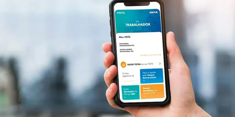Mão segura smartphone com aplicativo FGTS da Caixa aberto, mostrando saldo e opções de saque-aniversário e imediato