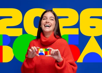 Mulher sorrindo segurando cartão do Bolsa Família representando desligamento voluntário do benefício