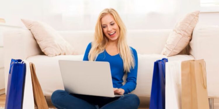 Mulher sorrindo enquanto realiza compras online pelo notebook