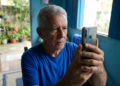 Aposentado utiliza celular em casa para realizar a biometria facial