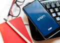 Celular com aplicativo do Enem sobre mesa de estudos