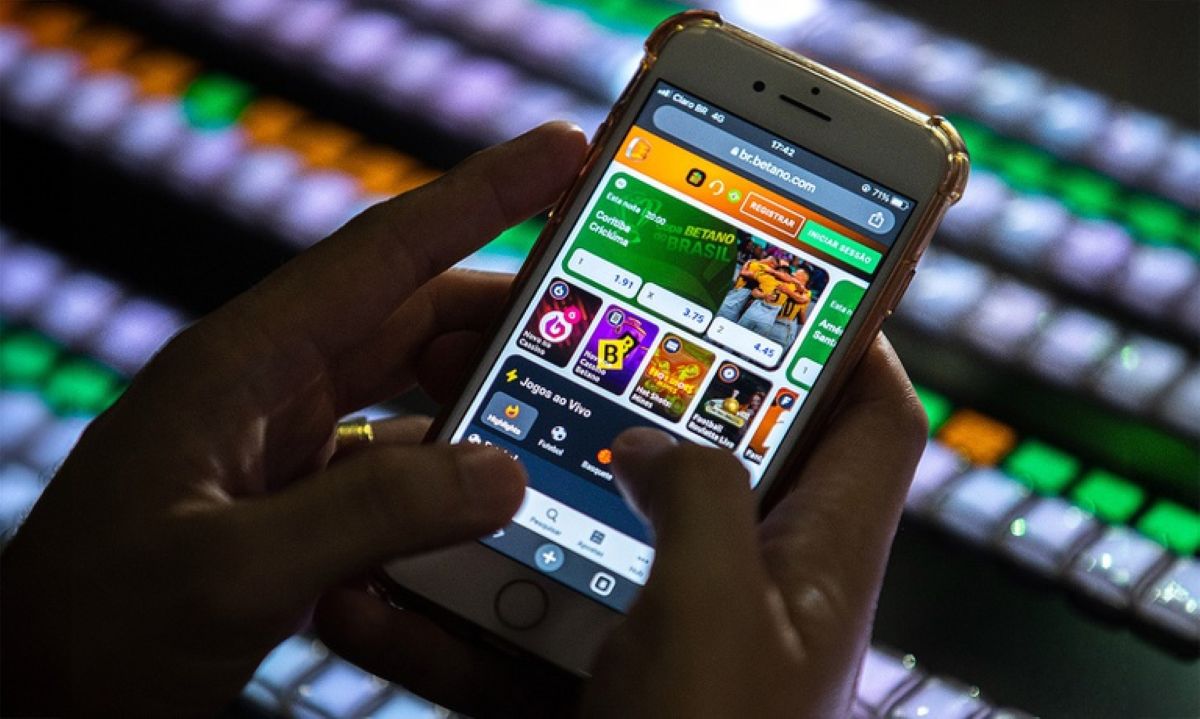 Pessoa utilizando aplicativo de apostas esportivas no celular