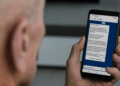 Aposentado lê no celular mensagem oficial do governo sobre a Prova de Vida do INSS pelo WhatsApp do GovBR