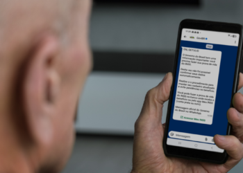 Aposentado lê no celular mensagem oficial do governo sobre a Prova de Vida do INSS pelo WhatsApp do GovBR