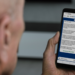 Aposentado lê no celular mensagem oficial do governo sobre a Prova de Vida do INSS pelo WhatsApp do GovBR
