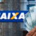 Mão segura cédulas de cem reais diante de fachada da Caixa Econômica Federal, em referência ao saque de até R$ 6.220