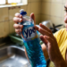 Mulher observa atentamente um frasco de detergente da marca Ypê