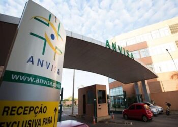 Fachada da sede da Anvisa em Brasília com totem amarelo exibindo logotipo