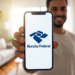 Homem exibe aplicativo Receita Federal aberto no smartphone em casa.