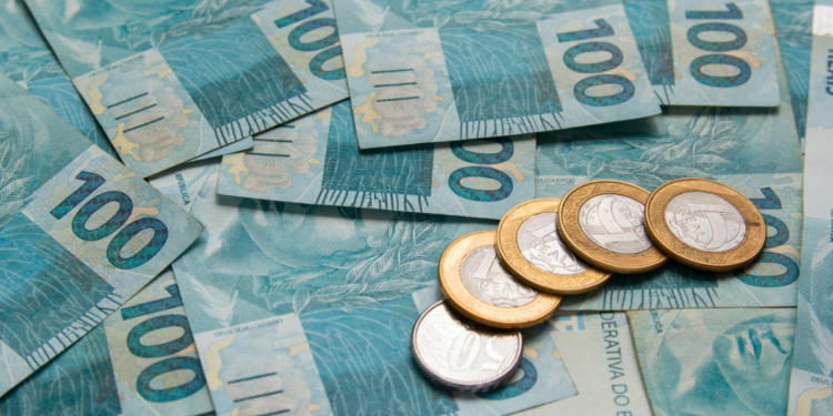 Notas de 100 reais e moedas de 1 real.