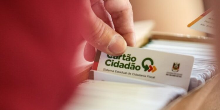 Mão retira Cartão Cidadão do Sistema Estadual de Cidadania Fiscal em caixa de cartões