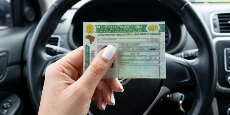Carteira Nacional de Habilitação do Brasil é exibida dentro de carro.
