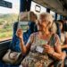 Idosa sorridente mostra Passe Livre e documentos sentada em poltrona de ônibus com reserva para idoso