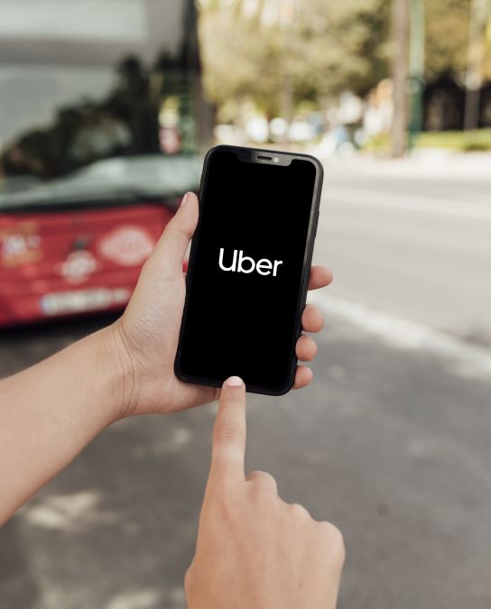 Pessoa usando aplicativo Uber para solicitar transporte urbano.