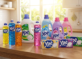 Linha completa de produtos de limpeza Ypê organizada em bancada de cozinha iluminada.