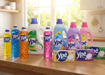 Linha completa de produtos de limpeza Ypê organizada em bancada de cozinha iluminada.