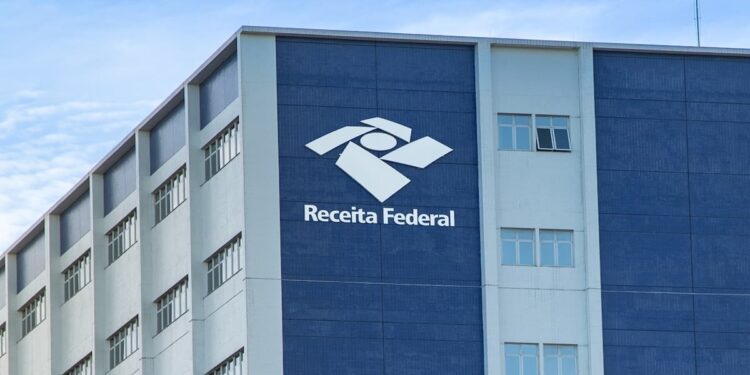 Prédio da Receita Federal com logomarca e céu azul ao fundo