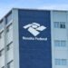 Prédio da Receita Federal com logomarca e céu azul ao fundo