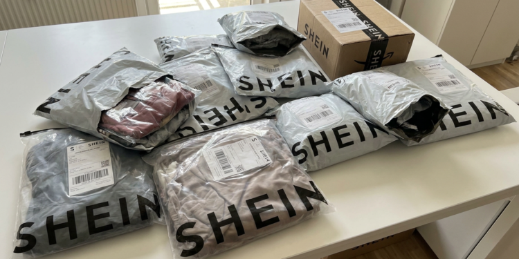 Pacotes da Shein encima de mesa branca.