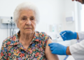 Senhora sendo vacinada em ambiente hospitalar.