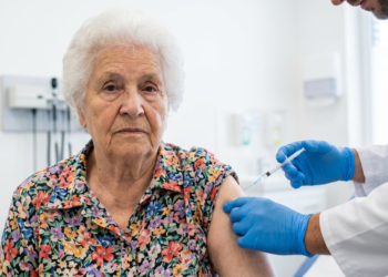 Senhora sendo vacinada em ambiente hospitalar.