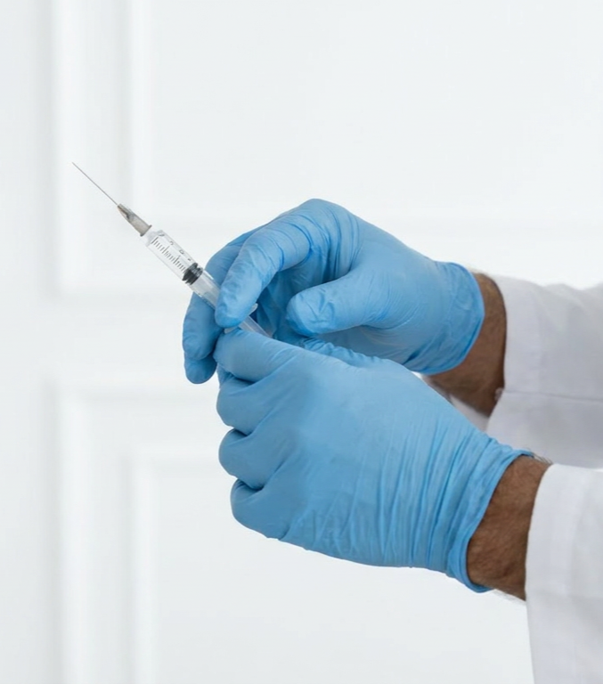 Profissional de saúde prepara seringa para aplicação de vacina.