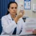 Médica de jaleco analisa frasco de PMMA com seringa e segura resolução marcada como proibido