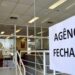 Aviso de agência fechada colado na porta de vidro de banco durante feriado