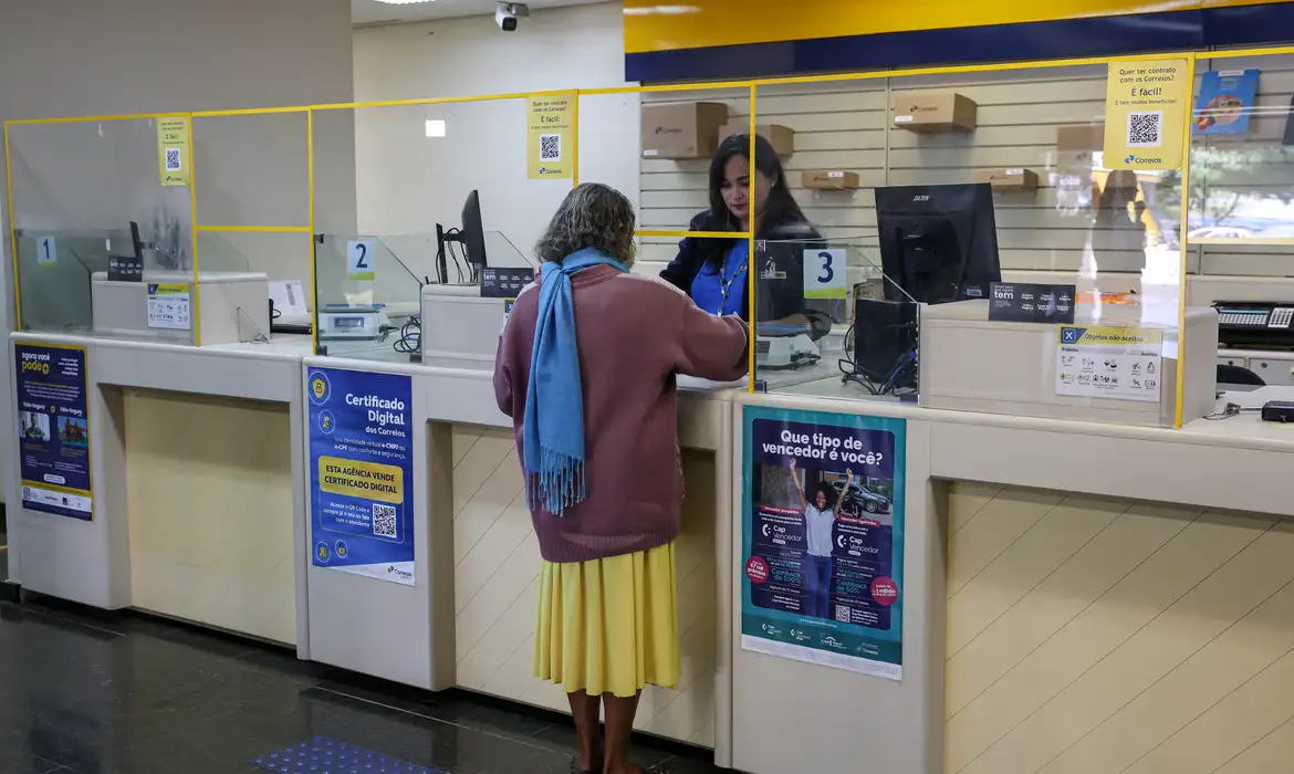 Cliente sendo atendida no guichê de uma agência, representando a alteração no horário de funcionamento dos bancos durante a Copa