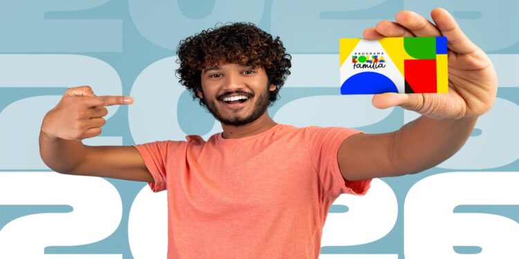 Homem sorri segurando o cartão do Bolsa Família diante do número 2026, em referência ao calendário de pagamentos de junho.