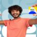 Homem sorri segurando o cartão do Bolsa Família diante do número 2026, em referência ao calendário de pagamentos de junho.
