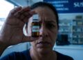 Corticoide sem prescrição, medicamento que pode causar glaucoma e cegueira, segurado em frente ao olho em unidade de saúde.