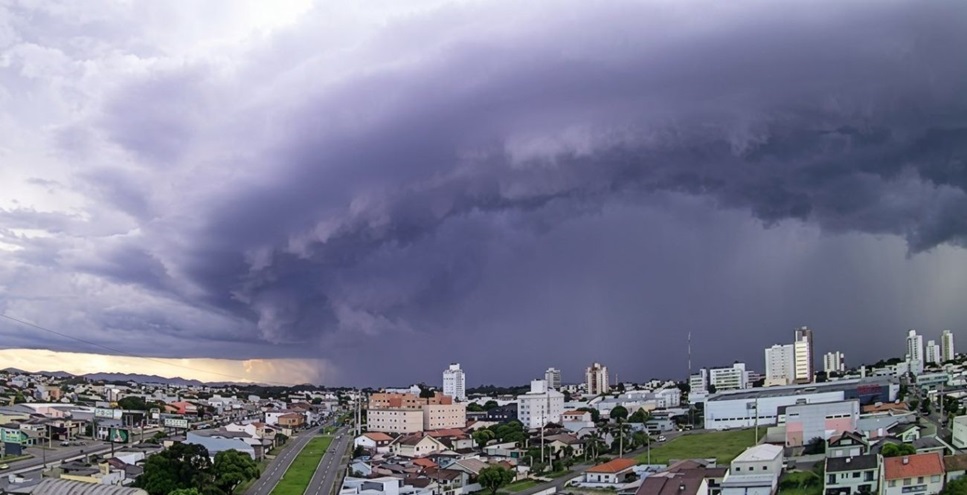 Bolsa Família 2025: Calendário Completo e Como Receber Seu Benefício 2 Nuvem escura densa cobre a cidade, trazendo chuvas sobre prédios e casas ao entardecer