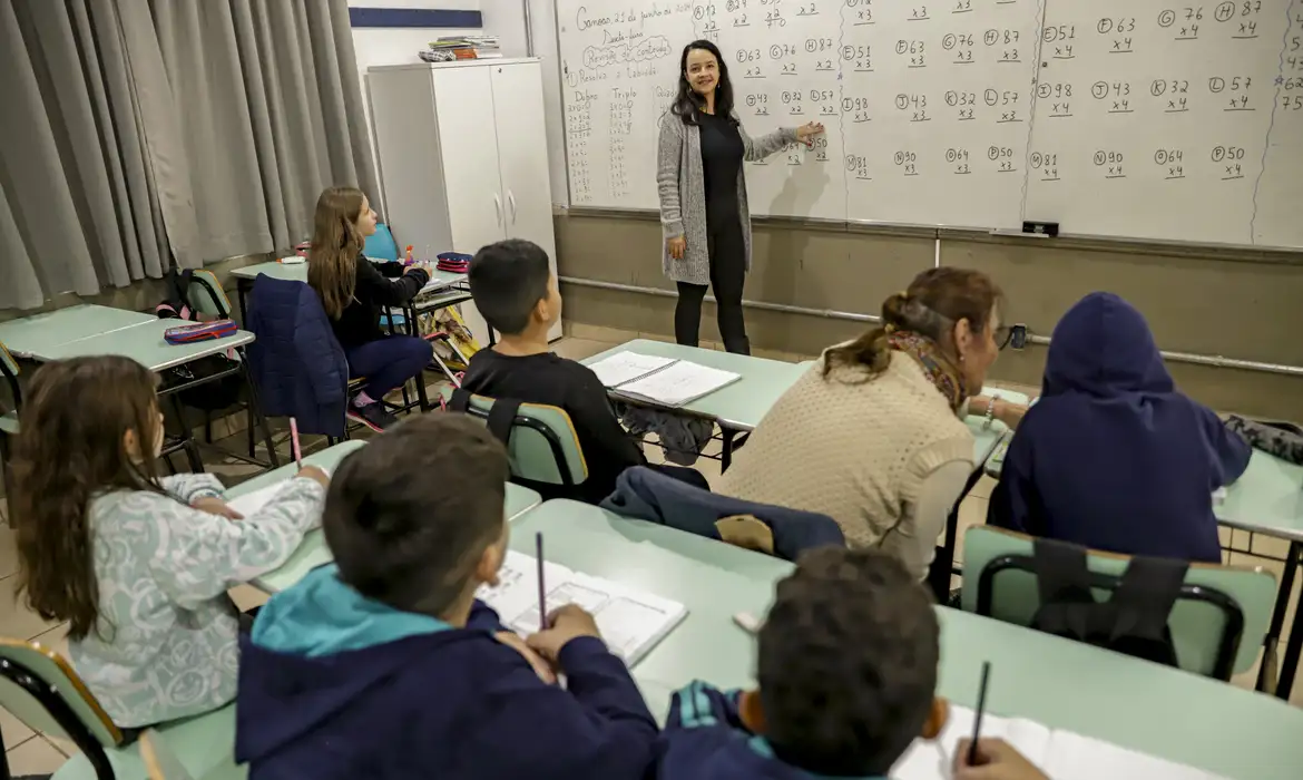 Professora em sala de aula da rede pública, categoria que teve o piso reajustado para R$ 5.130,63 com a nova lei