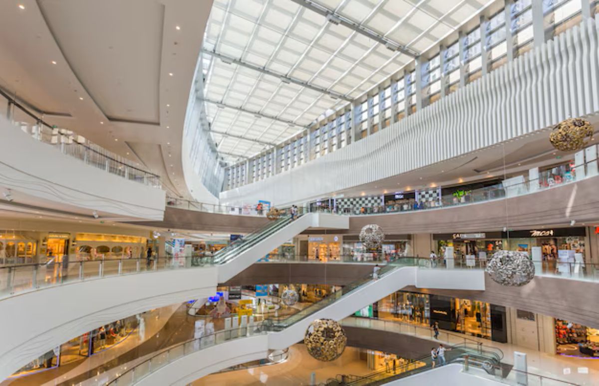 Interior amplo de shopping center com vários andares lojas e escadas rolantes
