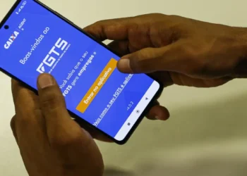 Trabalhador acessa o aplicativo FGTS da Caixa pelo celular