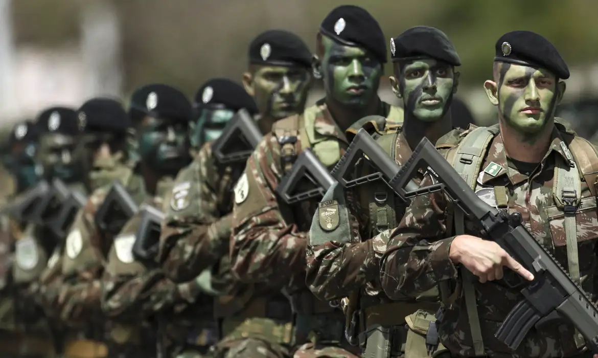 Fila de soldados do Exército Brasileiro em uniforme camuflado e armados, perfilados durante formação militar, etapa que aguarda os jovens incorporados após o alistamento de 2026