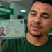 Homem segurando e exibindo a nova Carteira de Identidade Nacional em um posto de emissão de identidade, em referência aos prazos de troca do RG