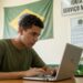 Jovem de camiseta verde faz o alistamento militar pelo notebook em uma sala da Junta de Serviço Militar, com a bandeira do Brasil ao fundo
