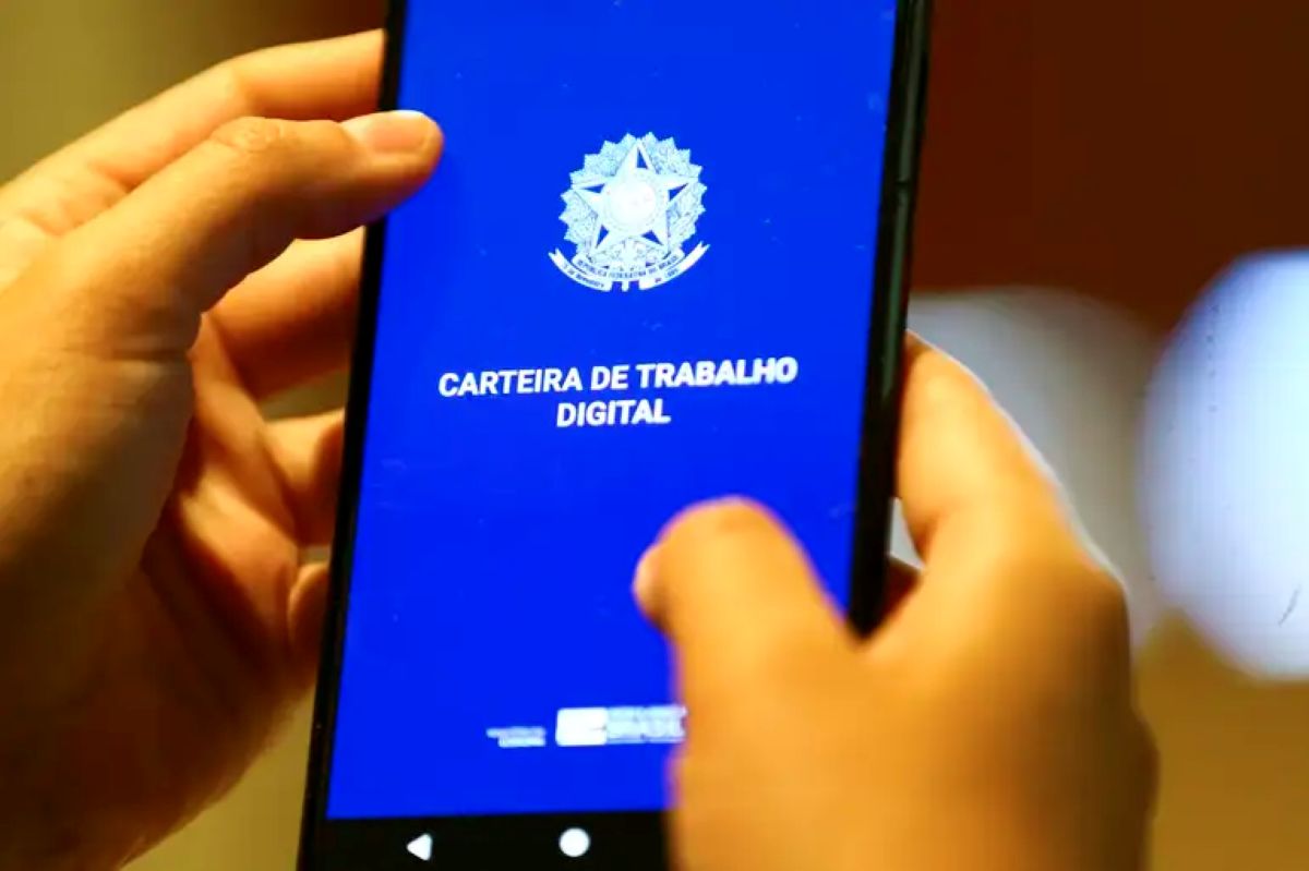 Aplicativo Carteira de Trabalho Digital aberto na tela do celular segurado por duas mãos