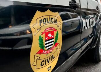 Brasão da Polícia Civil de São Paulo na lateral de uma viatura preta, durante a operação contra a lavagem de dinheiro do PCC.