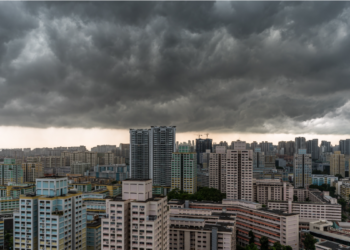 Nuvens escuras ameaçando tempestade sobre cidade de prédios altos.