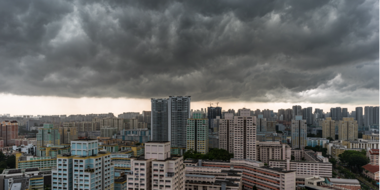 Nuvens escuras ameaçando tempestade sobre cidade de prédios altos.