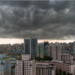Nuvens escuras ameaçando tempestade sobre cidade de prédios altos.