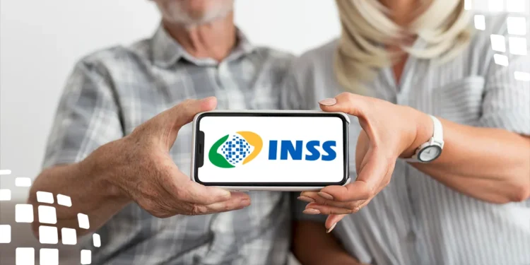 Dois idosos seguram celular mostrando logotipo do INSS centralizado na tela