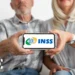 Dois idosos seguram celular mostrando logotipo do INSS centralizado na tela