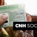 Pessoa segurando CNH brasileira próximo ao volante de carro, com destaque para o texto CNH Social